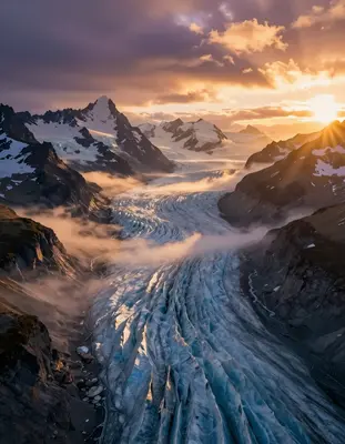 A breathtaking aerial view of Patagonian glaciers at golden hour, with rugged peaks and serpentine glacial rivers stretching 