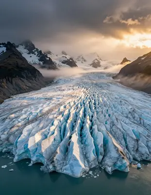 A sprawling aerial view of Patagonian glaciers at golden hour, with soft warm light dancing across the turquoise ice and sere